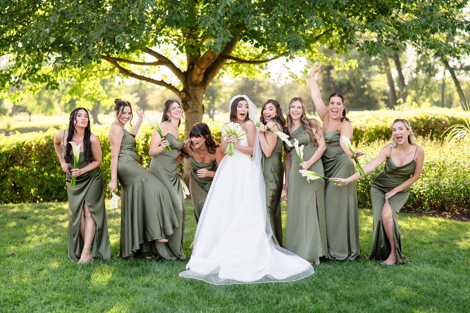 Large wedding party standing together in a lush field at the Allentown golf course.