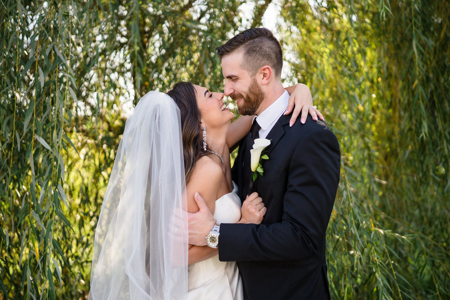 Bride and groom looking at each other during their sunset portraits by the water.