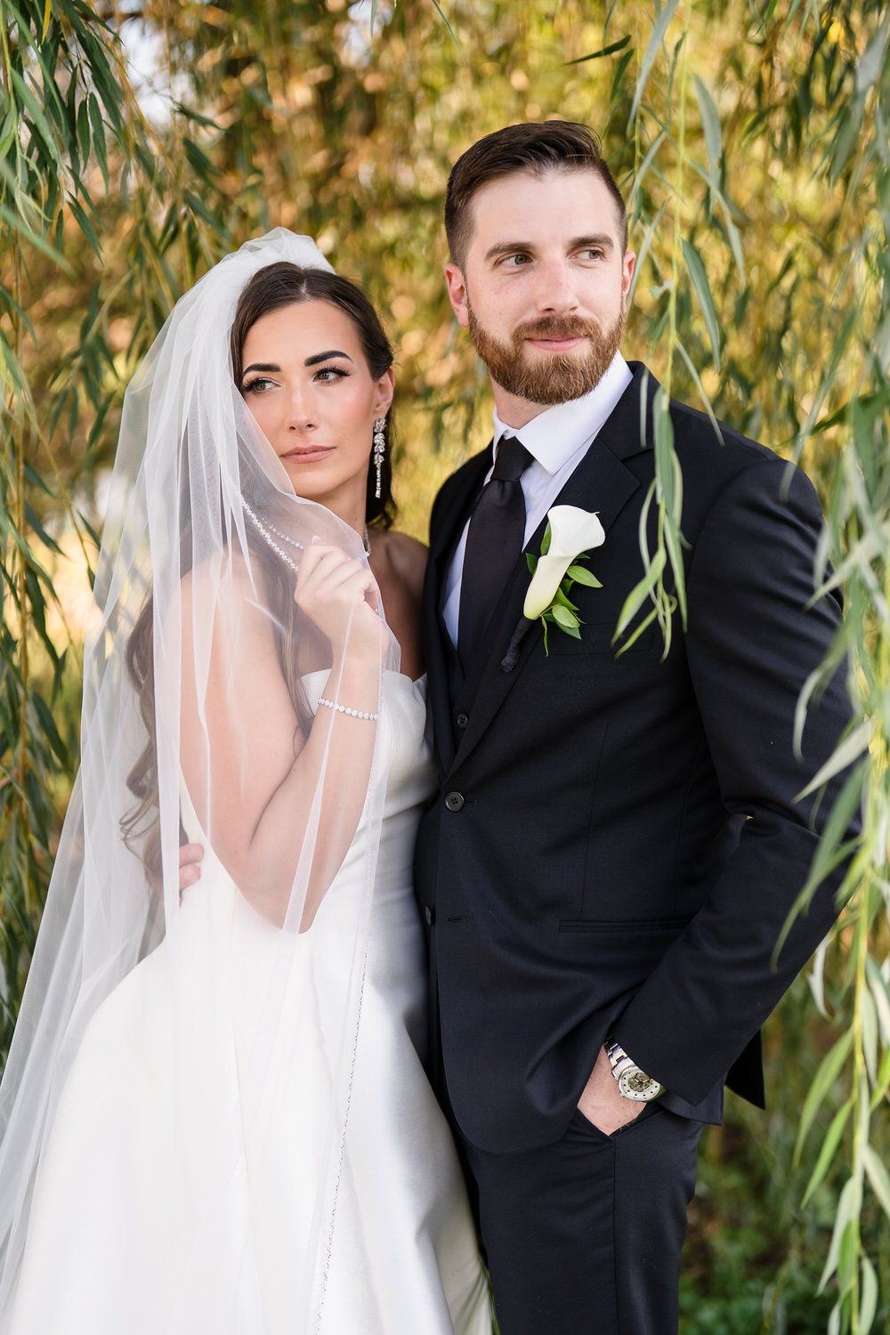 Couple posing together under a willow tree at The Club at Twin Lakes.