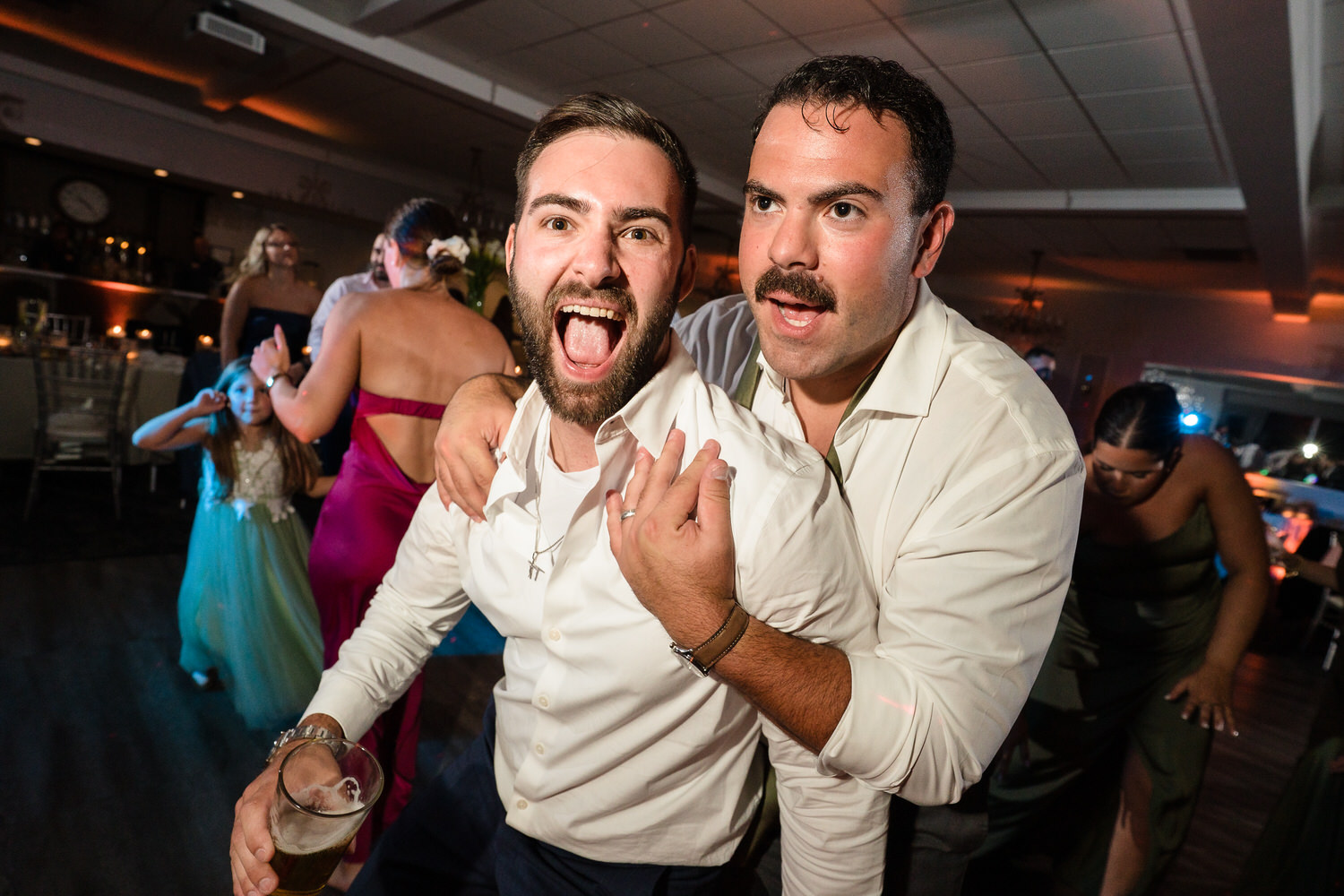 Two wedding guests singing along and celebrating during the party.