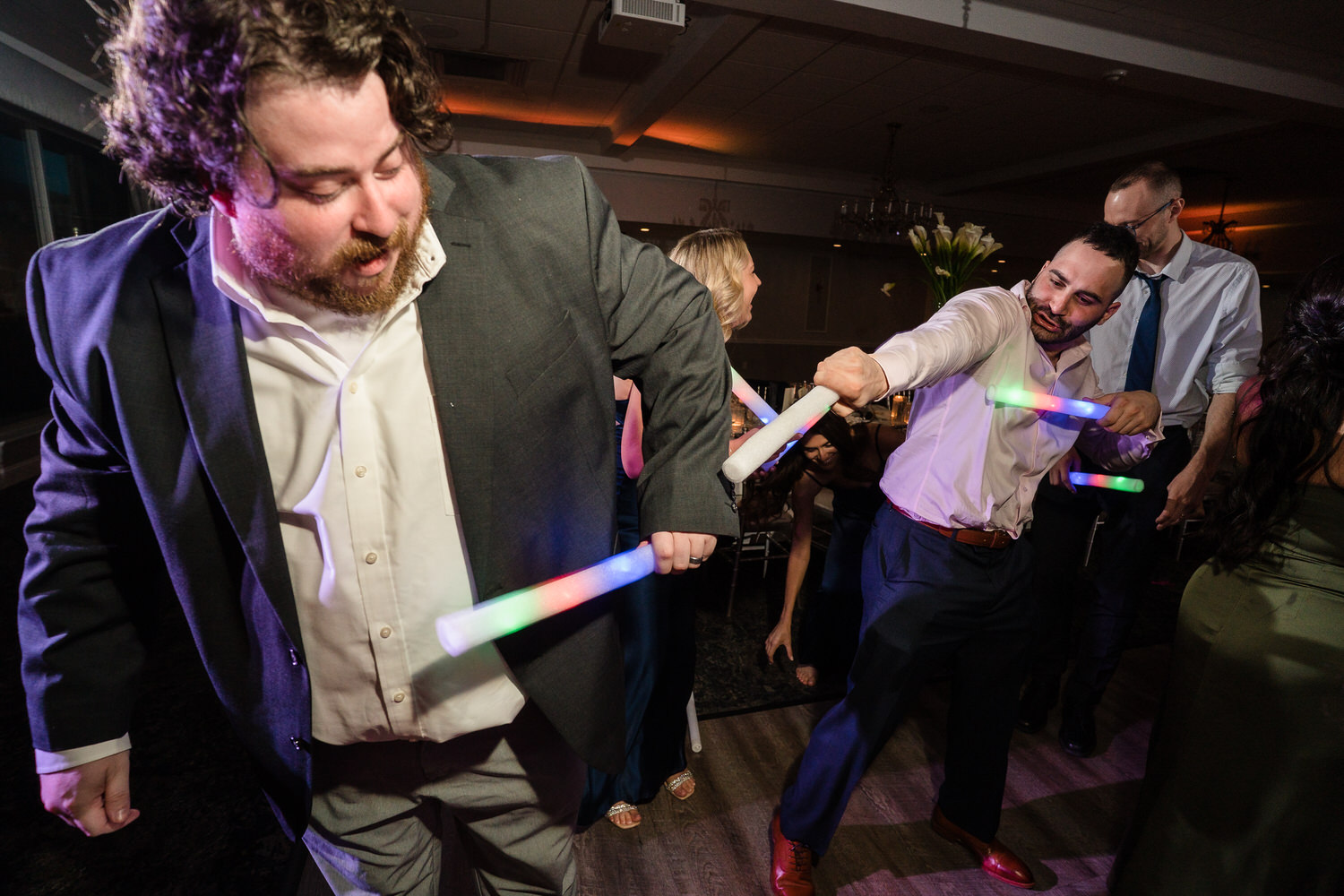 Candid moment of a wedding guest celebrating and dancing with friends.