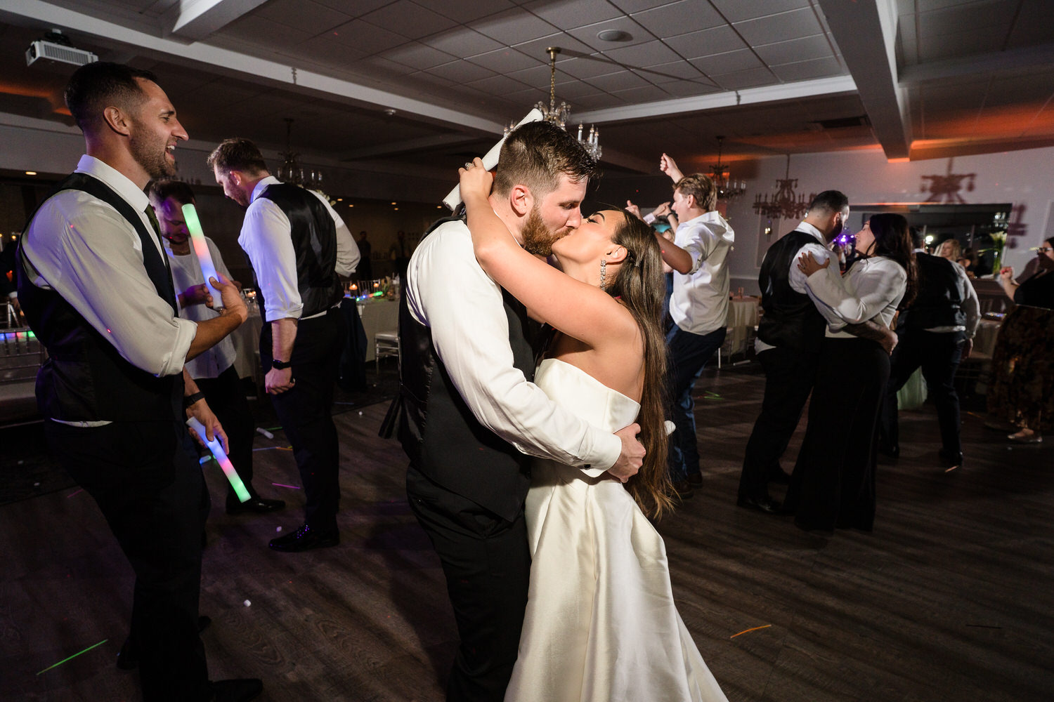 Bride and groom sharing an intimate dance in a ballroom with warm lighting.