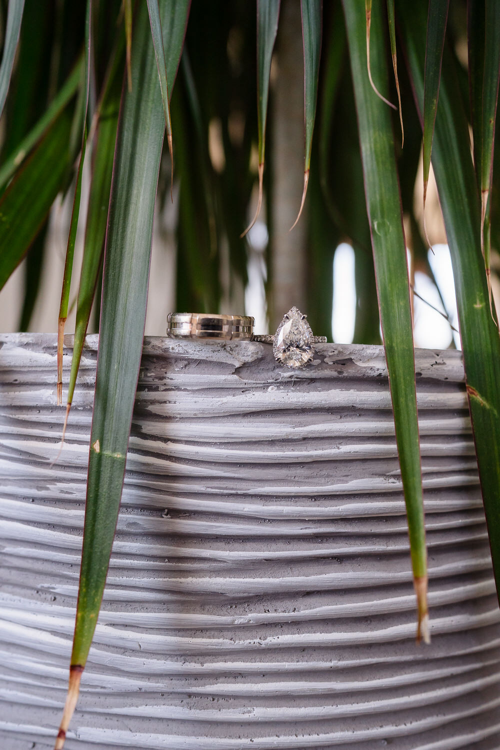 Detail shot of wedding rings resting on textured fabric.