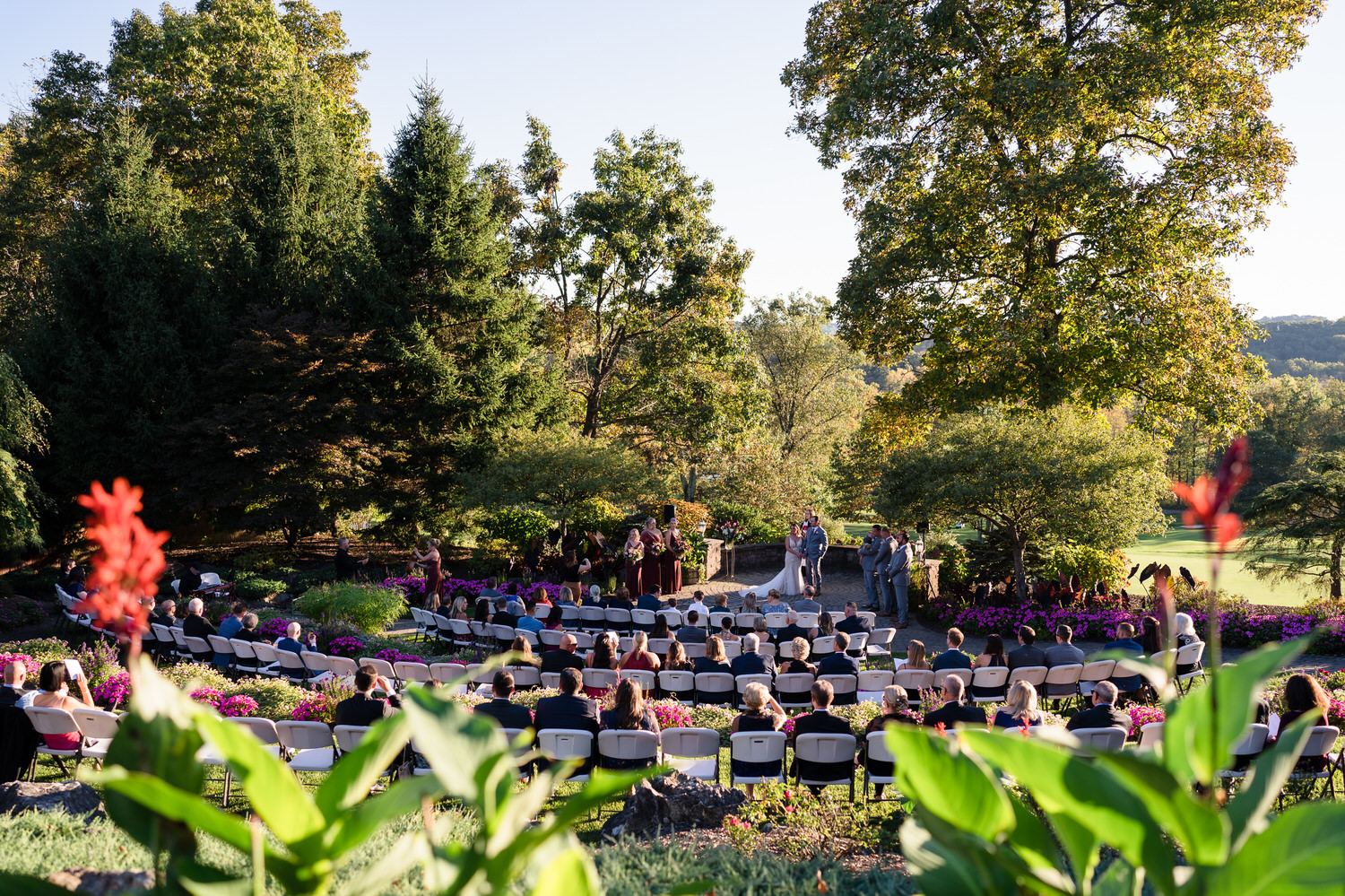 Scenic ceremony view of a bride and groom at the altar, framed by the tiered seating and mountains of Danielsville, PA.