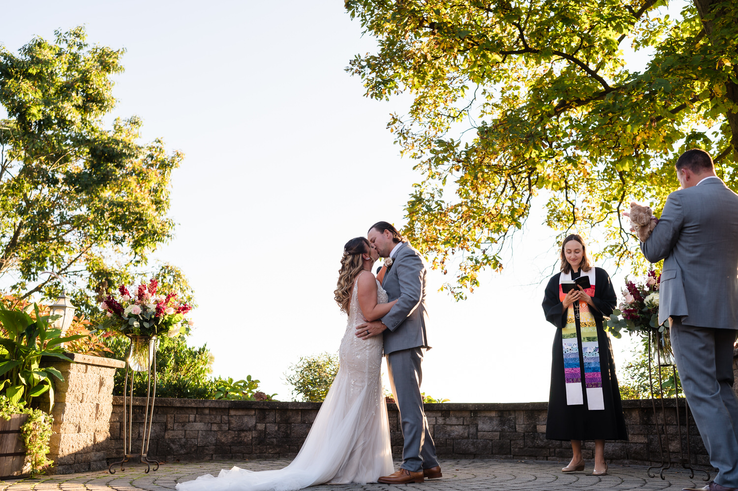 Wide-angle photograph of a bride walking down the aisle at the stadium-style Woodstone Gardens ceremony.