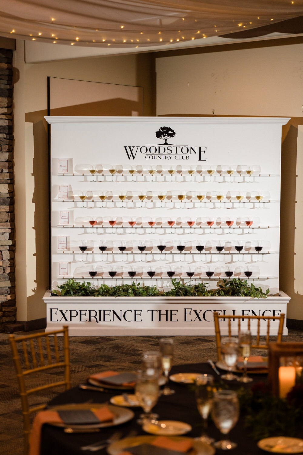 Full view of the "Experience the Excellence" guest seating chart display in the Woodstone Lodge lobby.