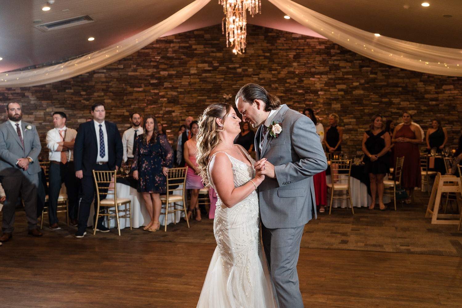 Natural light portrait of a bride and groom sharing their first dance in the spacious Woodstone reception area.
