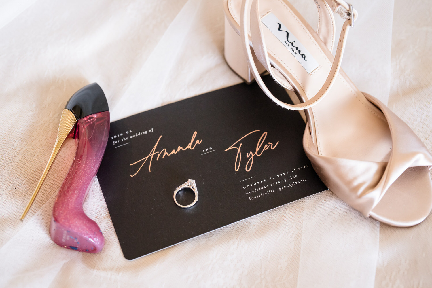 Flat-lay of a black and gold wedding invitation suite, showcasing the textured "grit and soul" of the stationery.