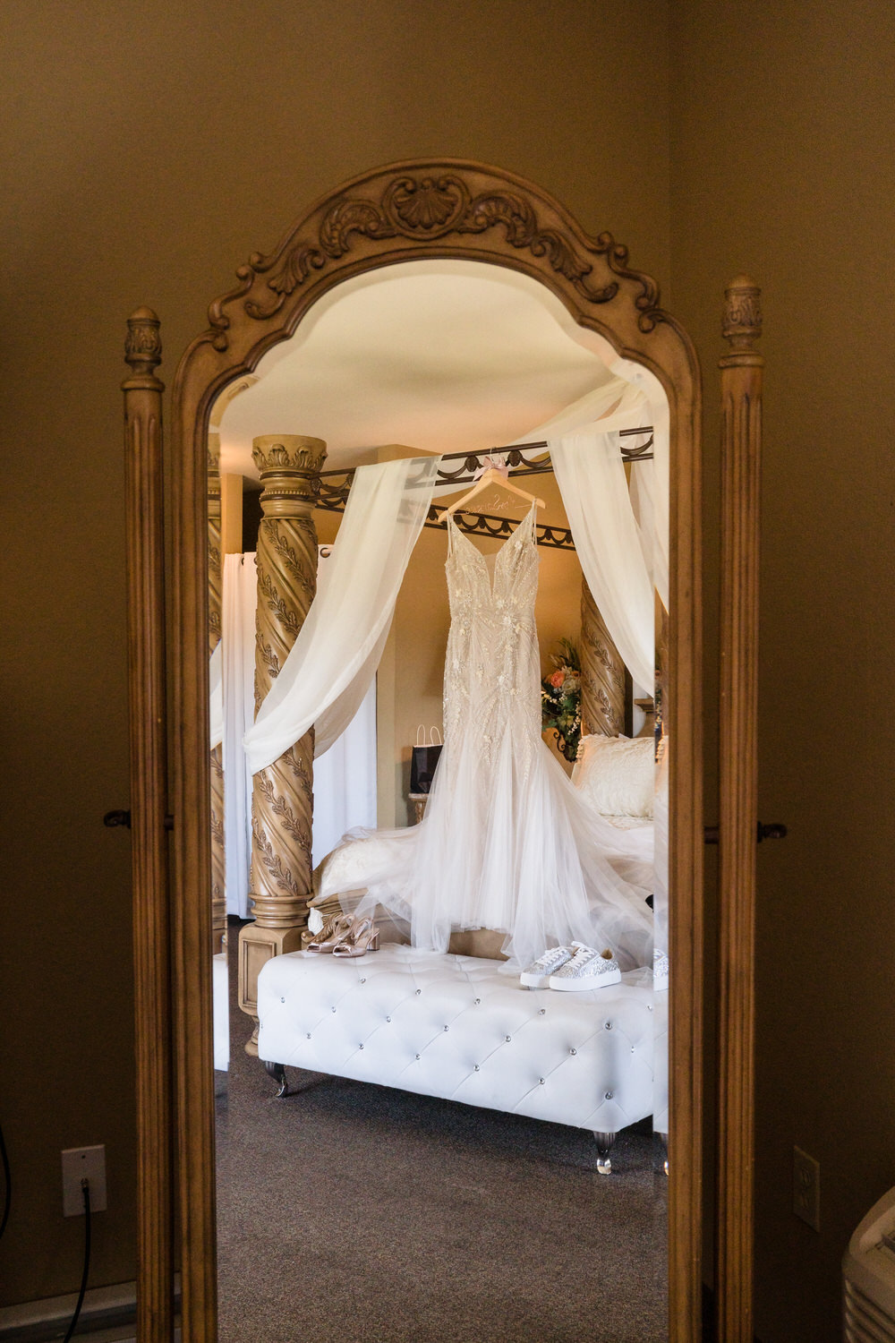Honest preservation of the wedding dress hanging in the four-poster bed of the Woodstone Lodge bridal suite.