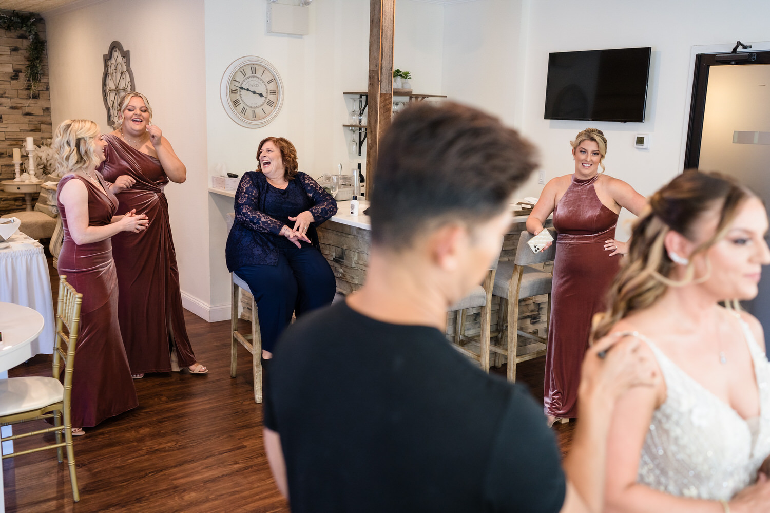 Candid reception shot of guests laughing and enjoying cocktails at the Woodstone Lodge.