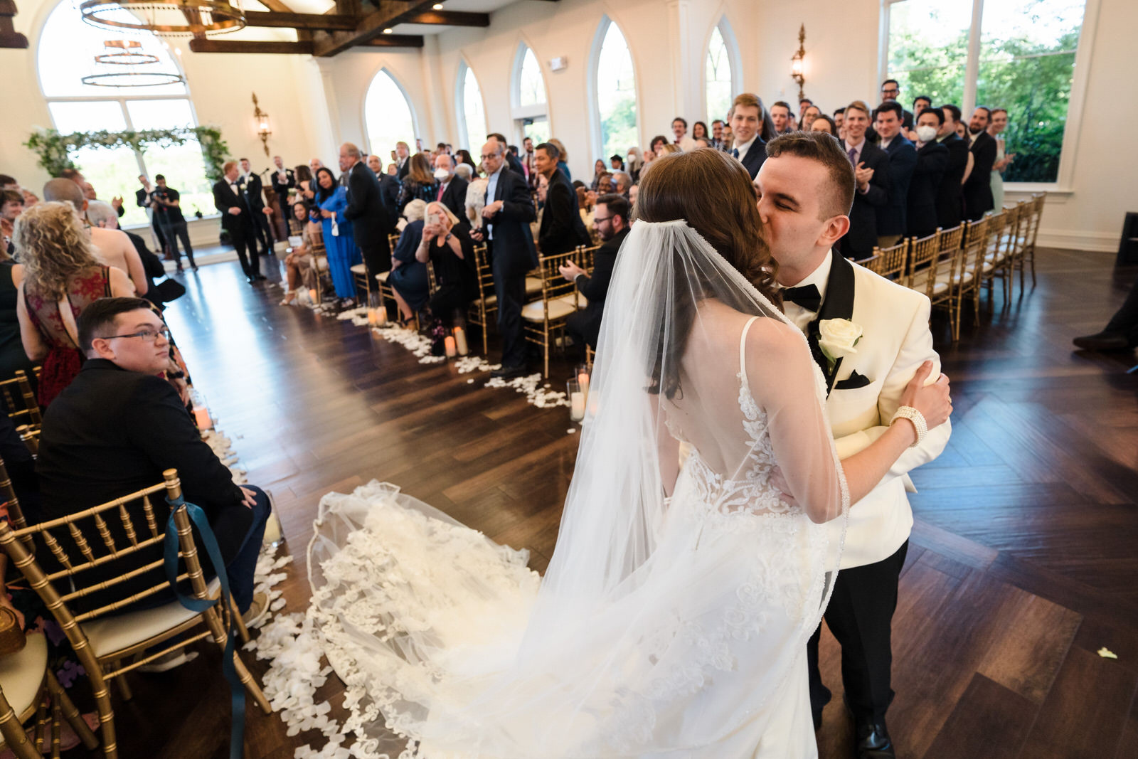 bride and groom kiss down the wedding aisle