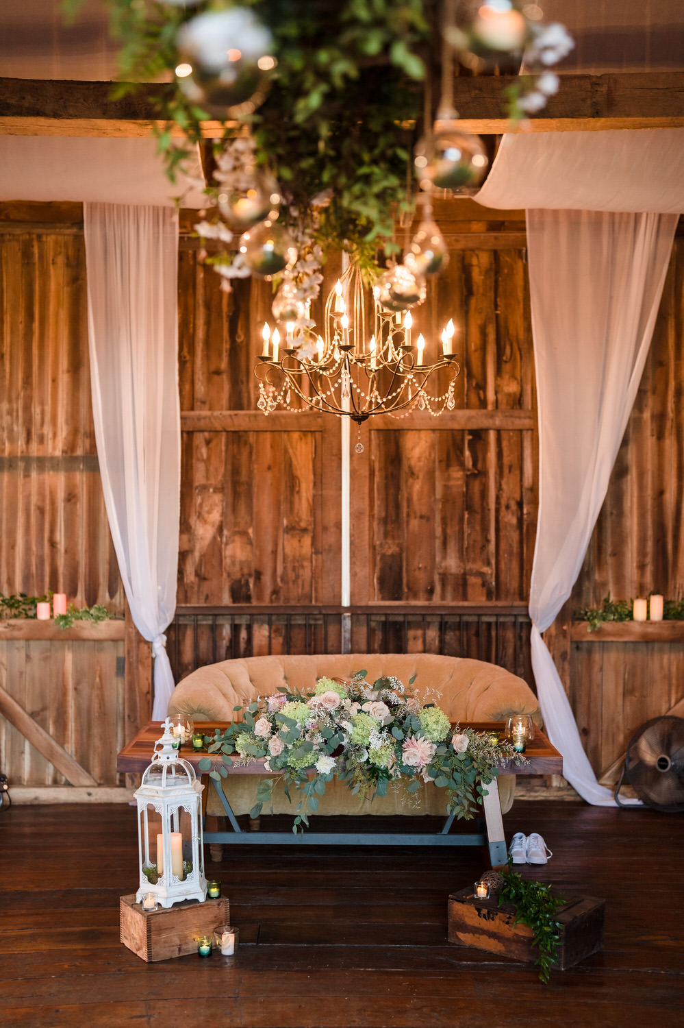Intimate sweetheart table setup with a vintage sofa and floral arrangements.
