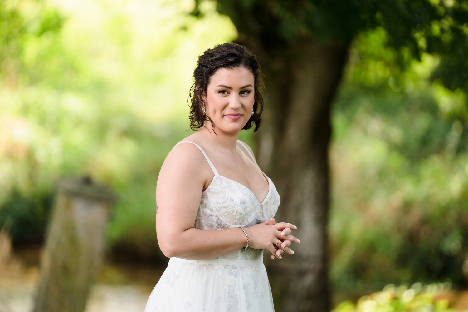 Wide shot of a first look or quiet moment between the couple in a green field.