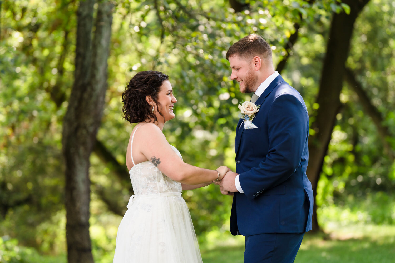 Intimate moment of the bride and groom holding hands during their outdoor portraits.