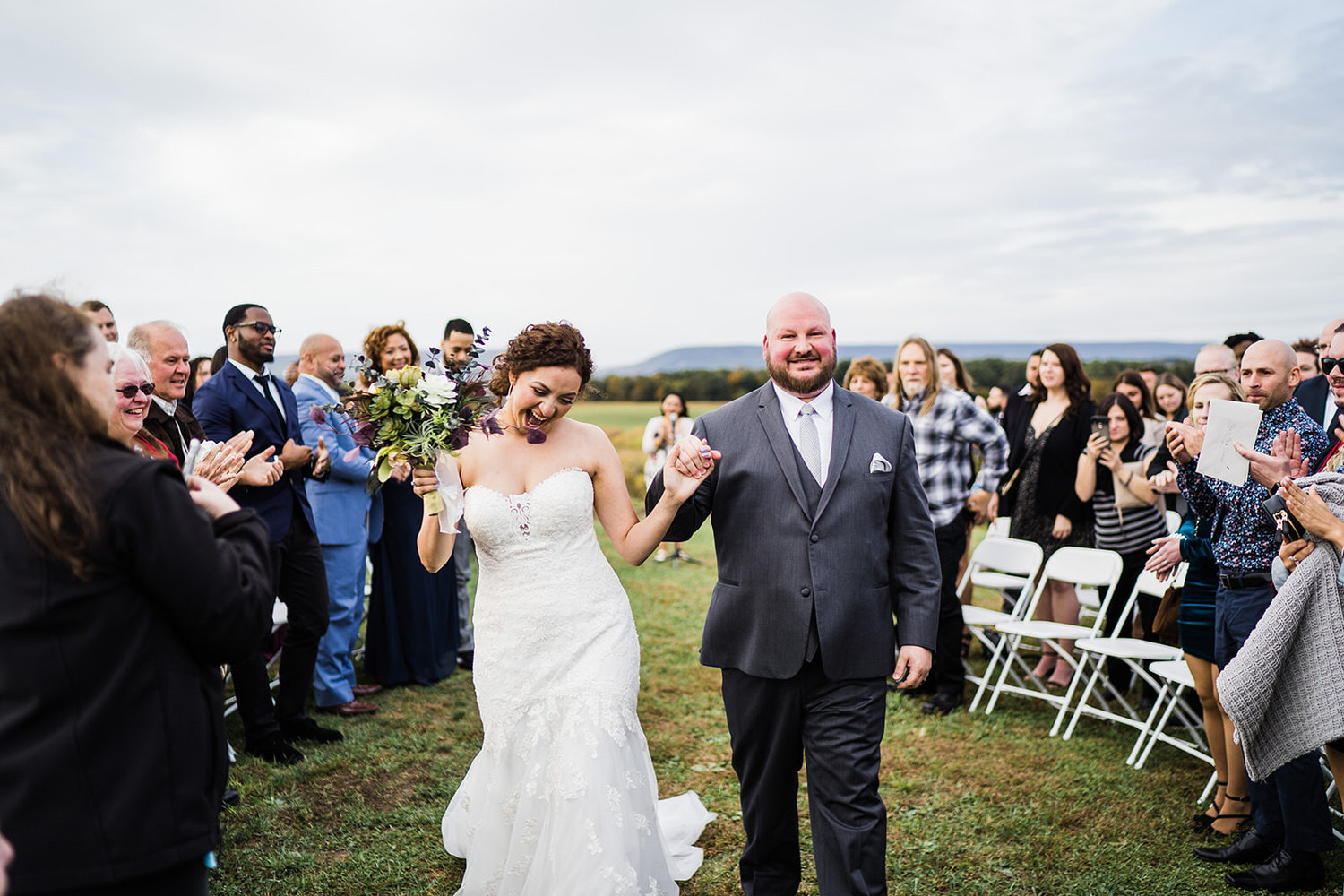 Newlyweds walking through a cheering crowd during an outdoor ceremony on the 200-acre estate at Chelsea Sun Inn in Mount Bethel, PA.