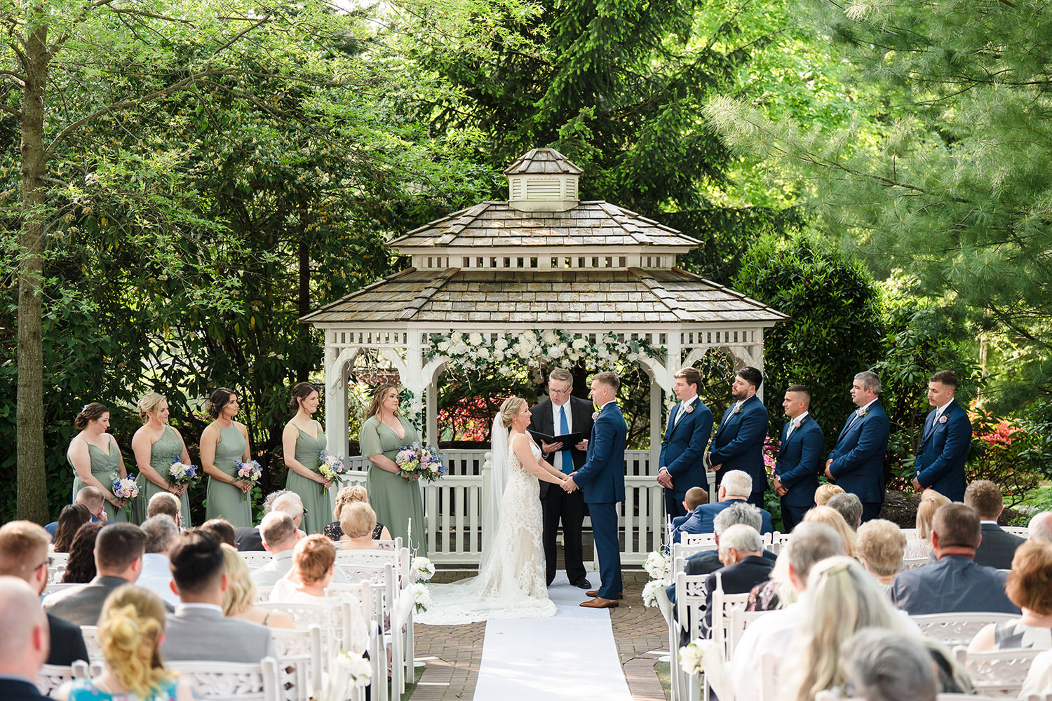 Outdoor wedding ceremony at a white floral-draped gazebo at Meredith Manor in Montgomery County.