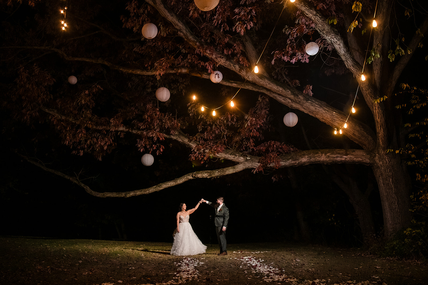 Romantic nighttime wedding portrait under a 200-year-old oak tree with hanging lanterns at Monterre Vineyards in Orefield, Lehigh Valley PA.
