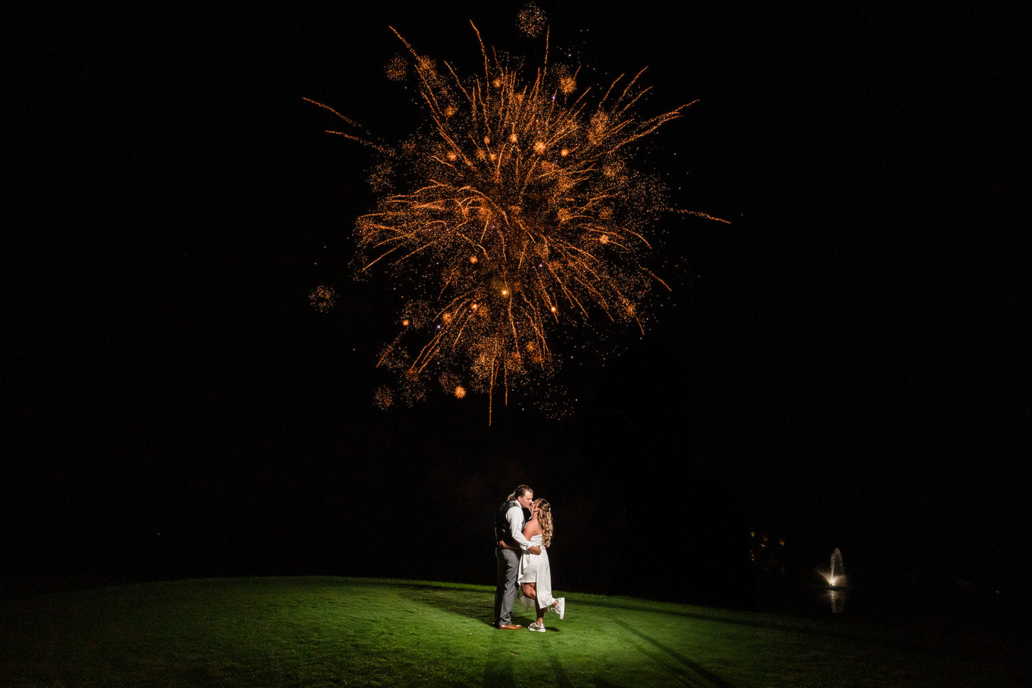 Newlyweds kissing on the golf course under a massive fireworks display at Woodstone Country Club in Danielsville, Lehigh Valley PA.