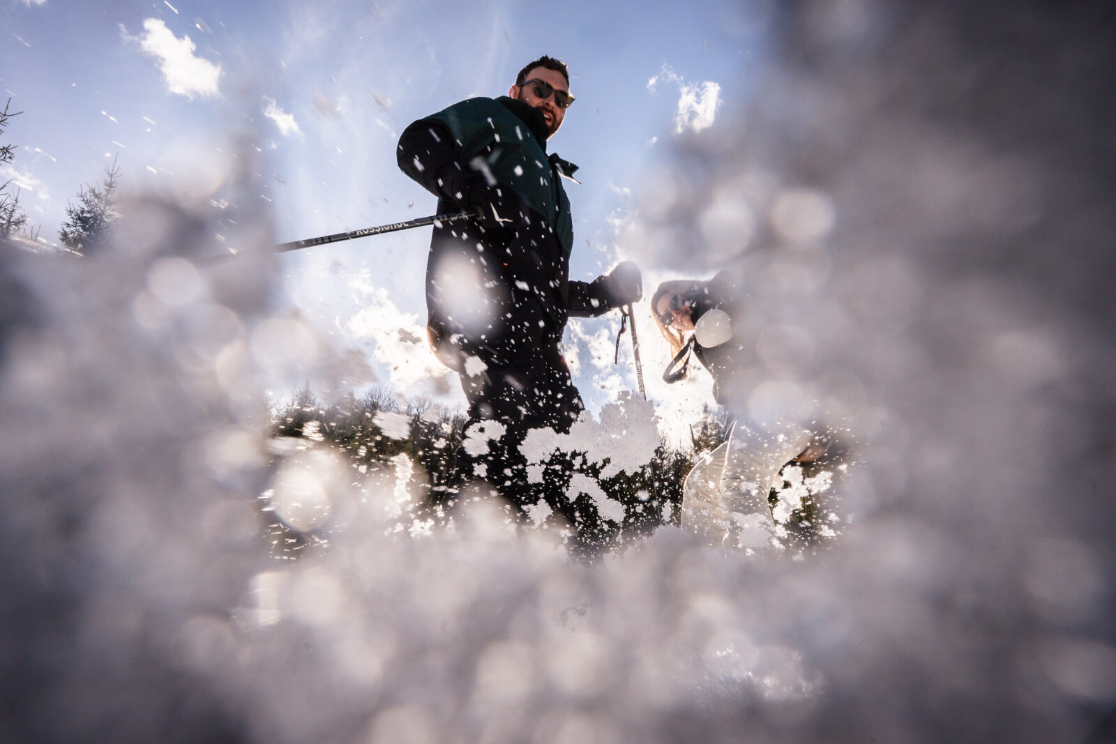 Action shot of snowboarding couple riding through fresh powder on Elk Mountain