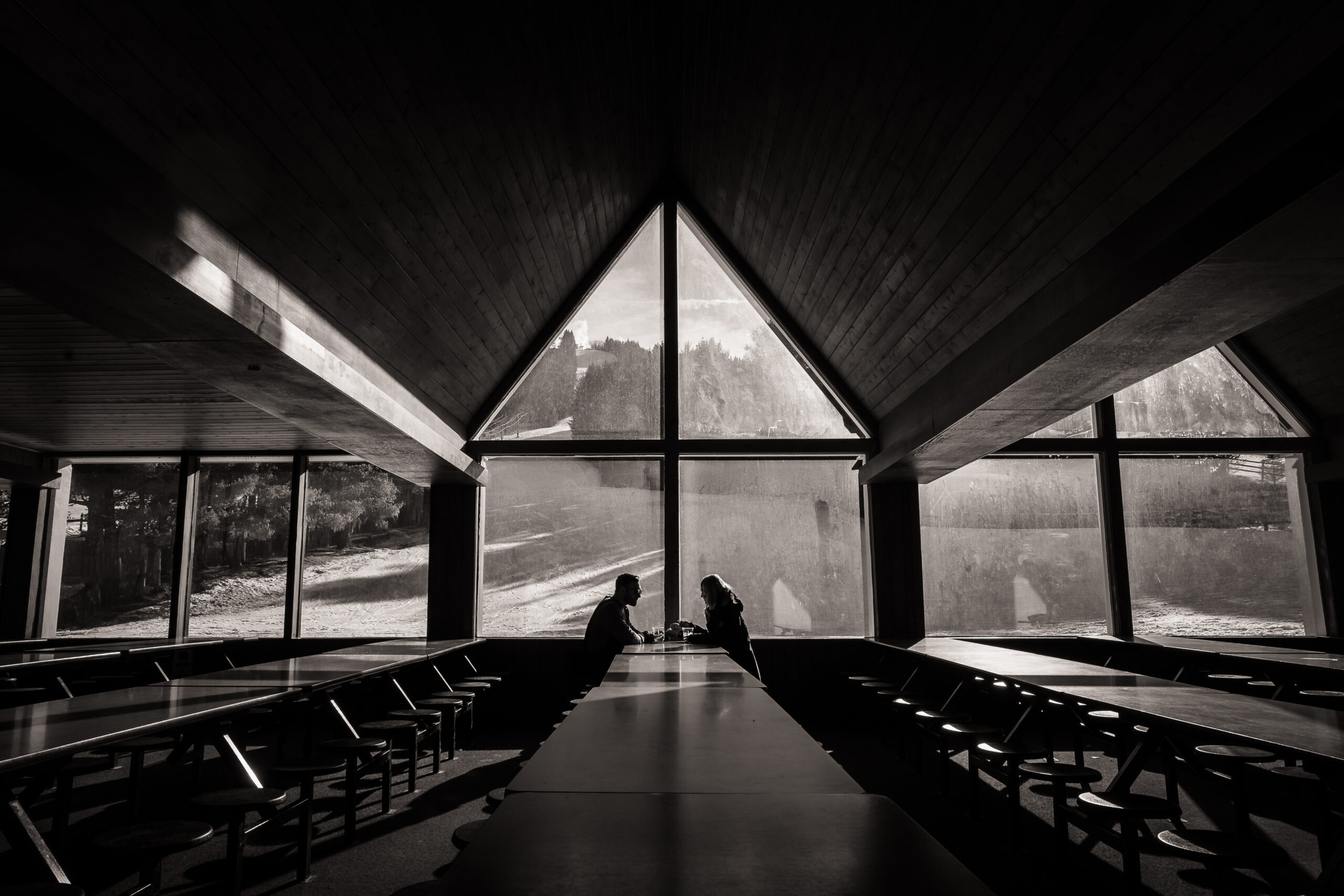 Black and white photo of A-frame lodge interior with couple silhouette at Elk Mountain