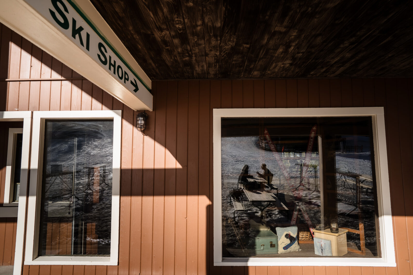 Rustic ski lodge exterior at Elk Mountain with wooden architecture and winter setting with couple silhouetted in the reflection