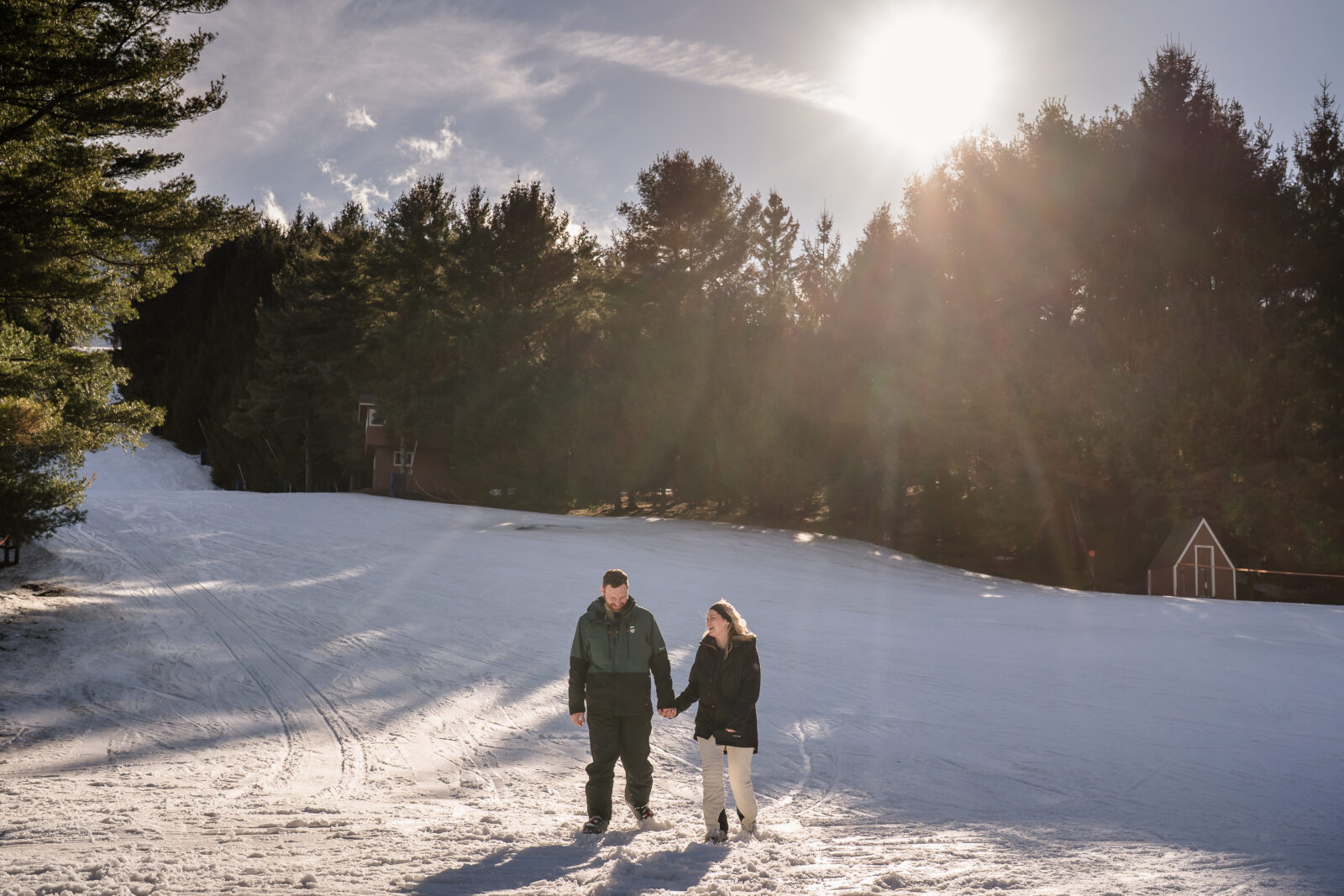 Couple walking through snowy slopes at Elk Mountain during winter engagement session