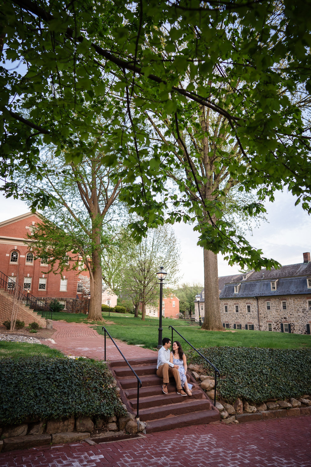 Wide angle photo of a couple sitting on the stairs on Moravian university grouds