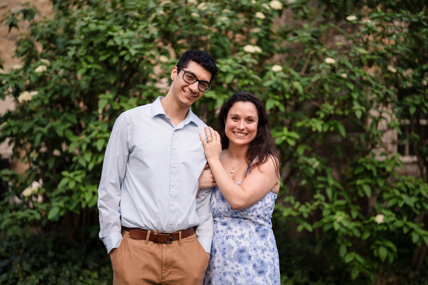 Couple laughs together among full spring greenery
