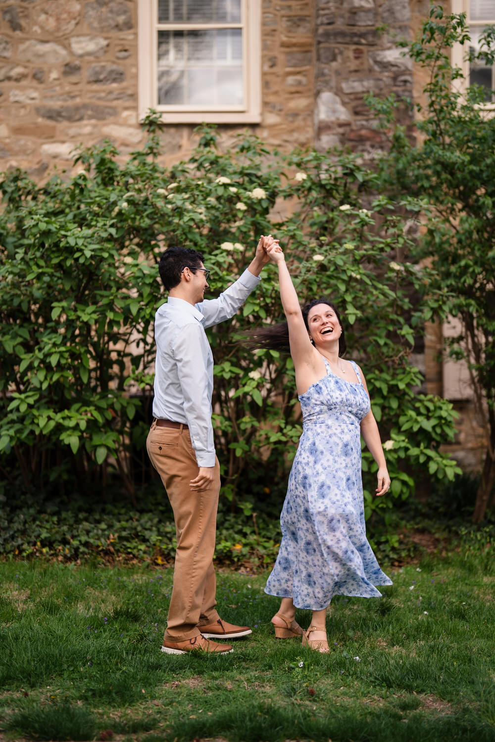 Couple shares a candid twirl in soft afternoon light
