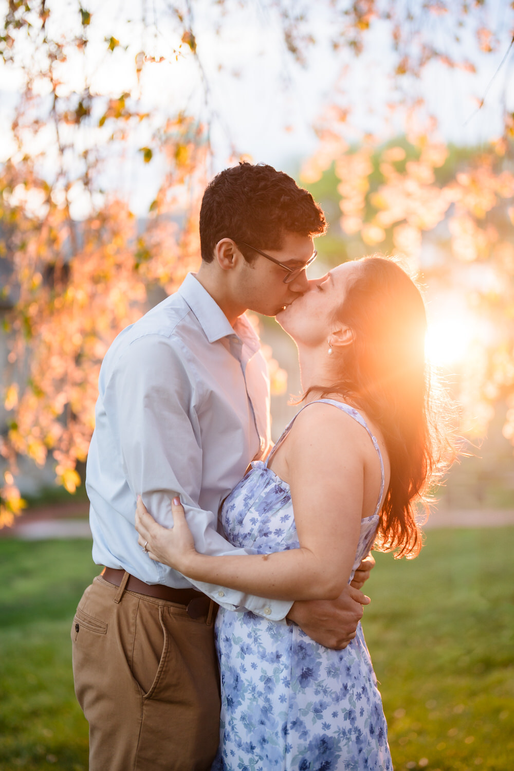 Couple kisses with warm sunset flare at Moravian University
