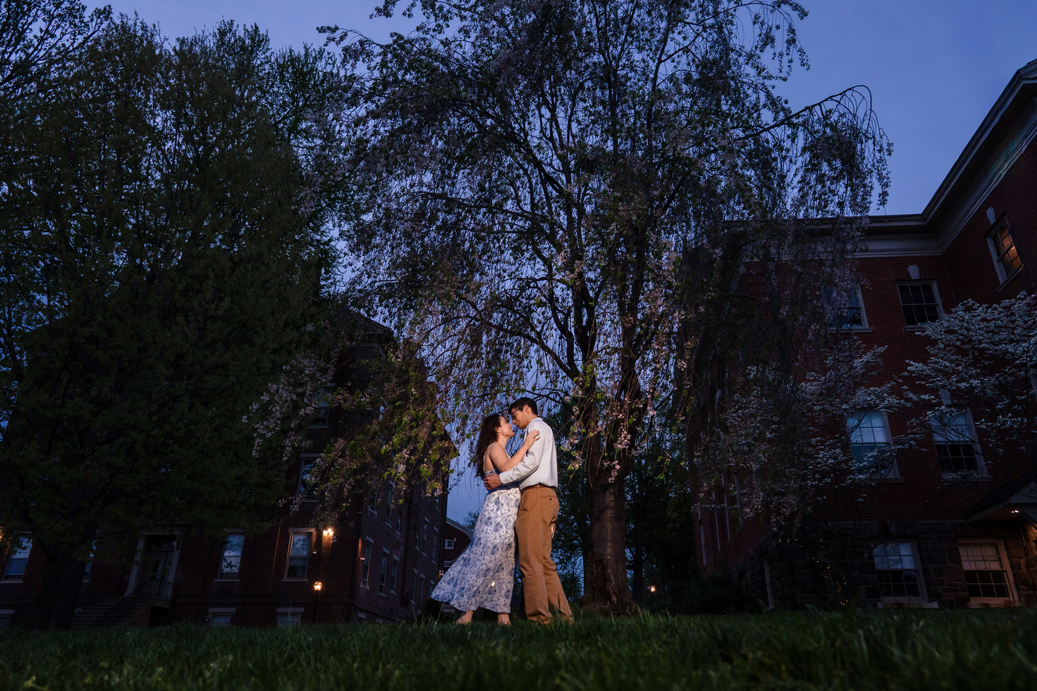 Forehead-to-forehead moment beneath spring trees at Moravian University
