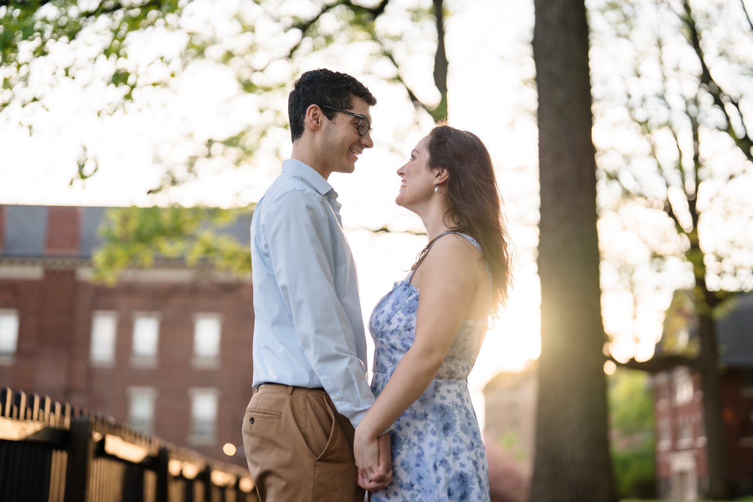 couple looking at one another while holding hands with the sun behind them in God's Acre, Bethlehem PA