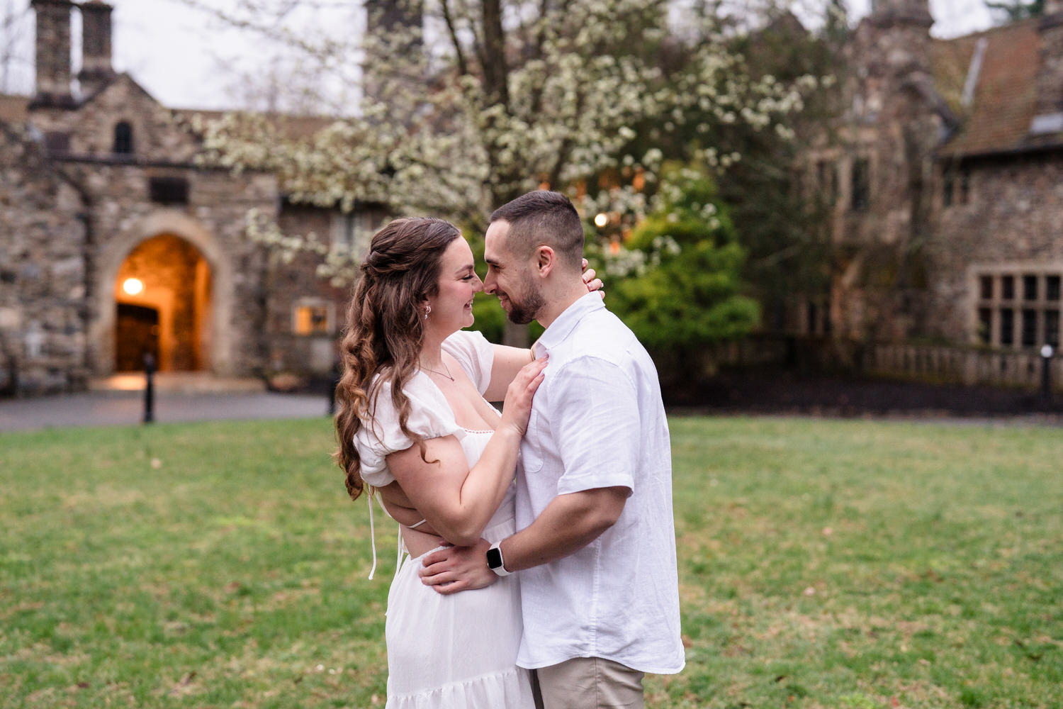 Romantic engagement portrait of couple holding each other in front of garden estate