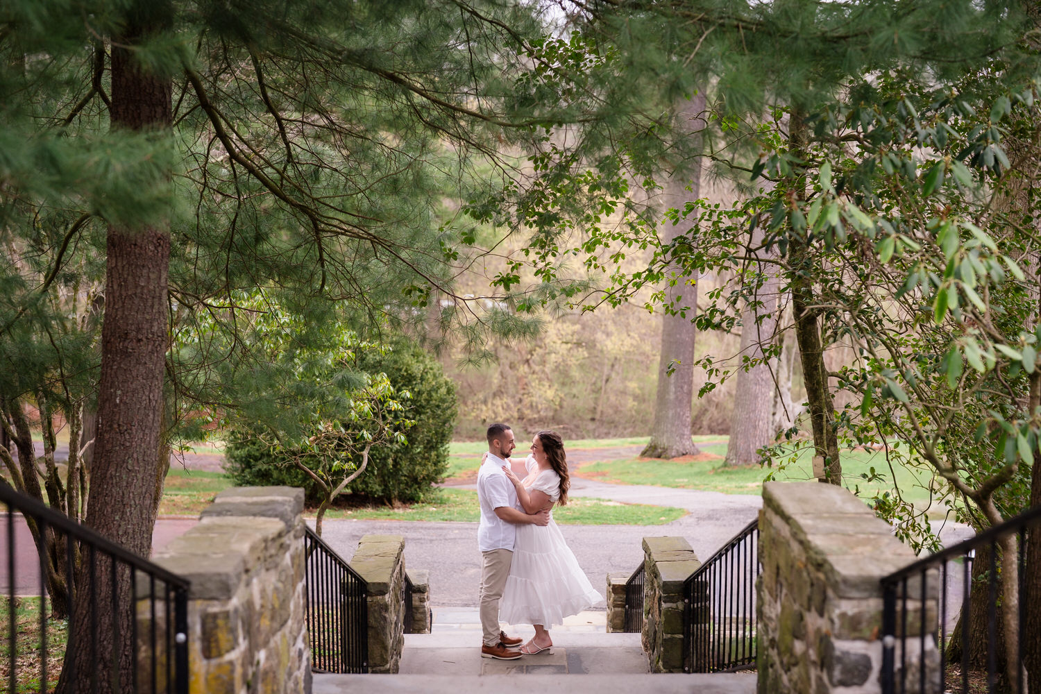 engagement photo of couple kissing on a staircase at Ridley Creek State Park