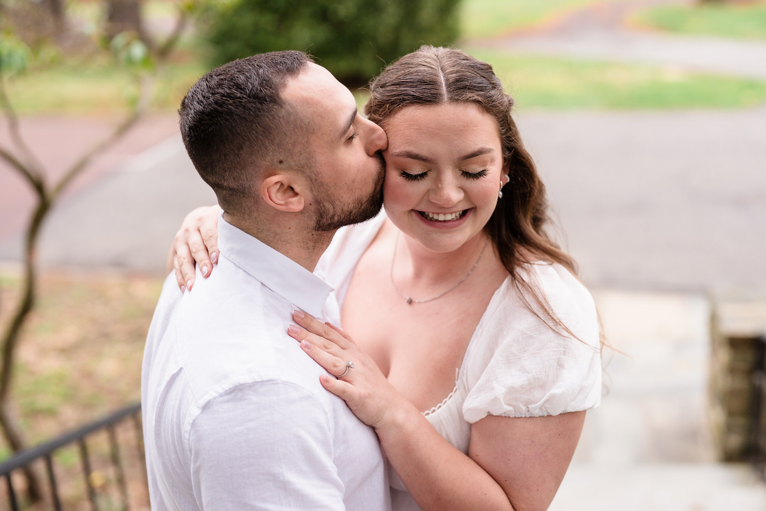 Close-up engagement photo of couple smiling with intimate pose outdoors