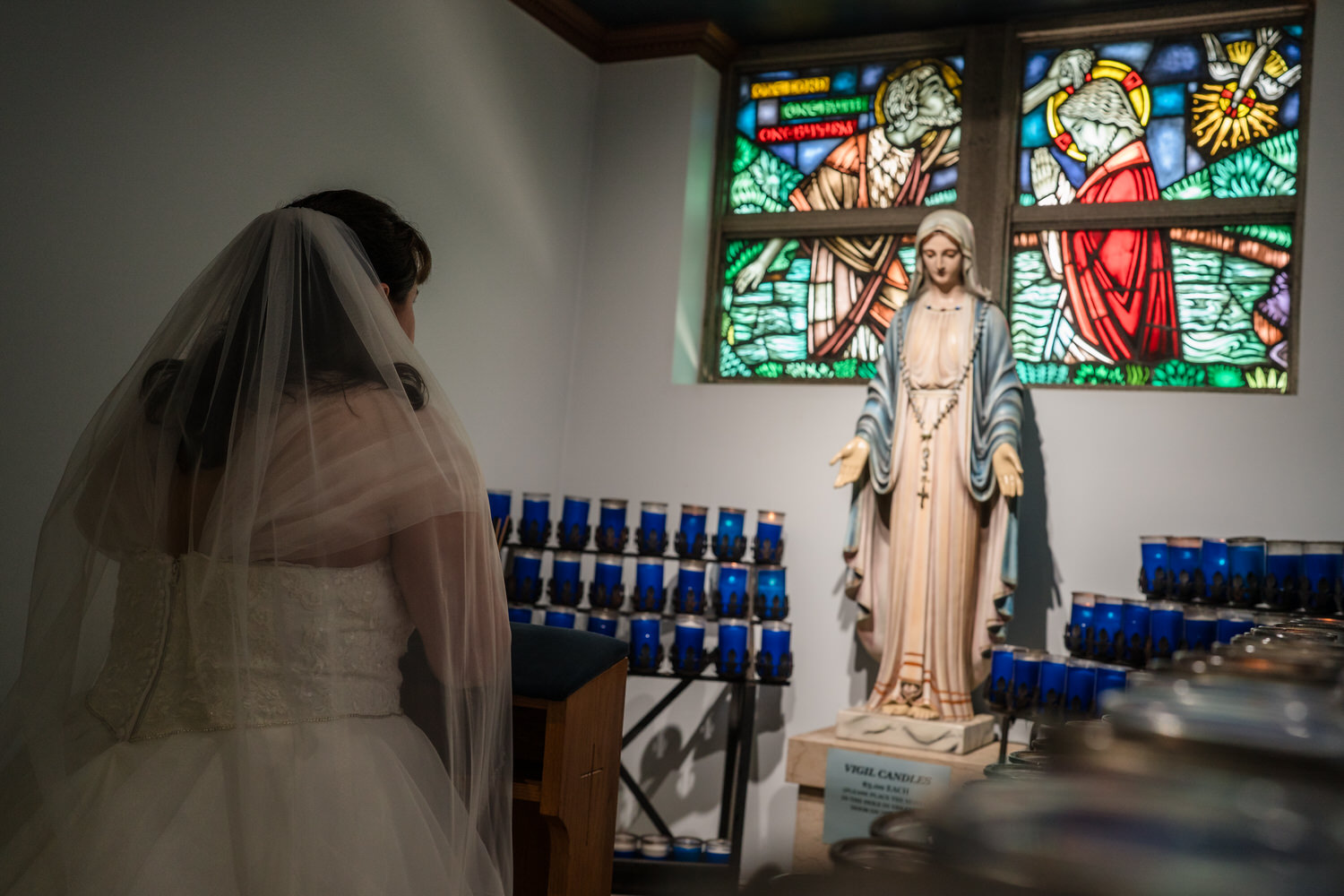 Bride reflected near stained glass windows before wedding ceremony
