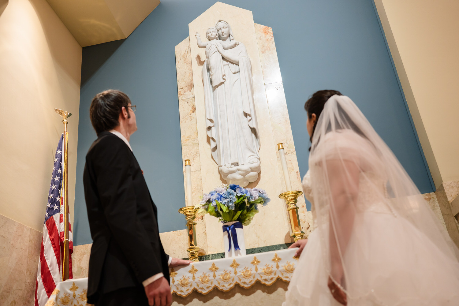 Bride and groom standing before altar during Catholic wedding ceremony