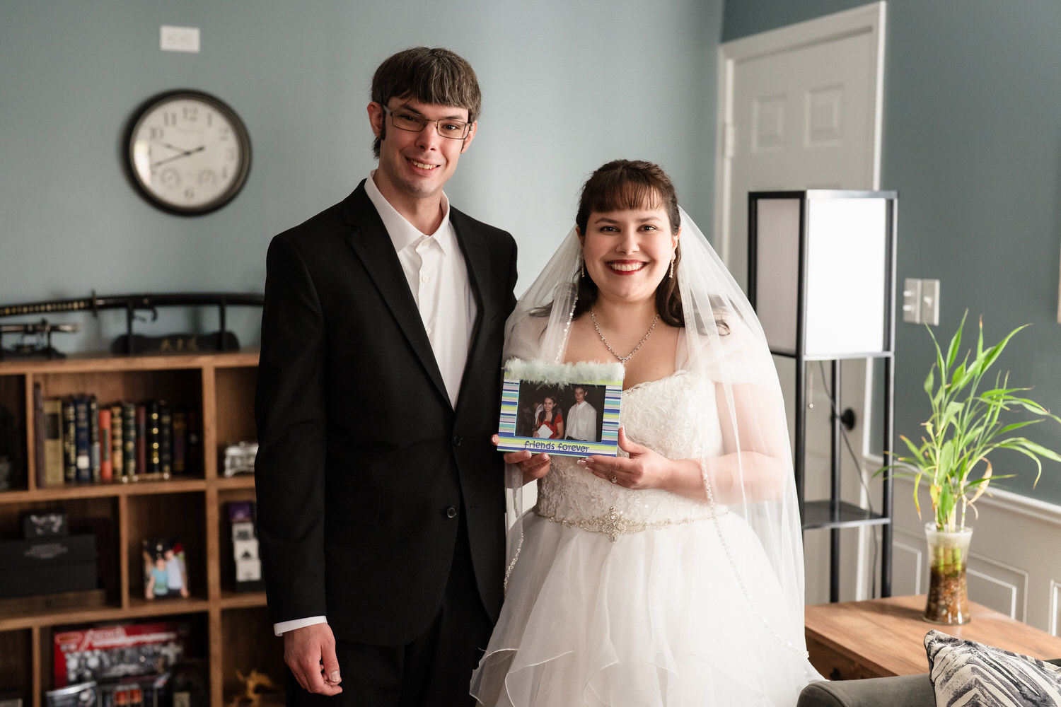 Bride and groom holding framed photo during wedding day tribute