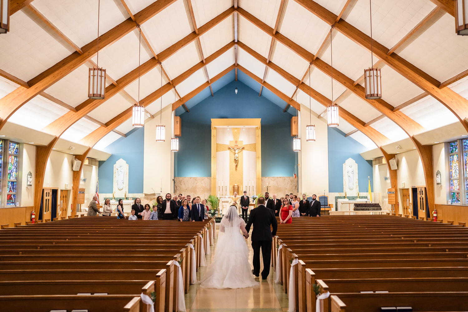 Wide church ceremony view with bride and groom at altar