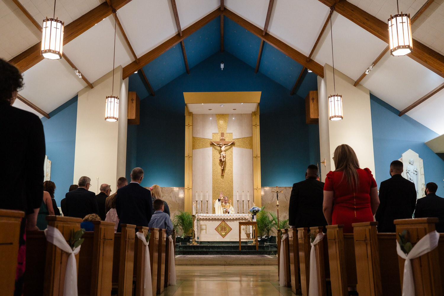 Catholic church wedding ceremony with guests seated in pews