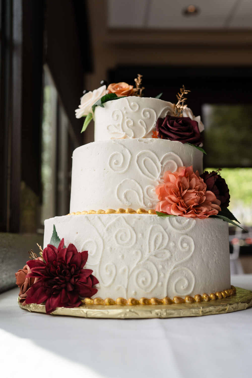 Three-tier wedding cake with floral decorations at reception