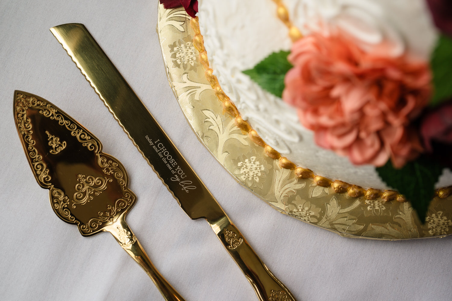 Wedding cake slice detail with gold serving utensils