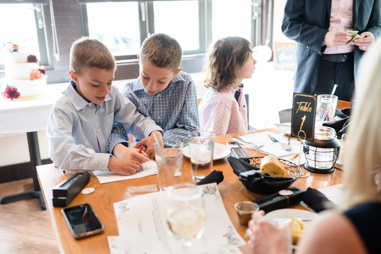 Children drawing at wedding reception table with coloring pages
