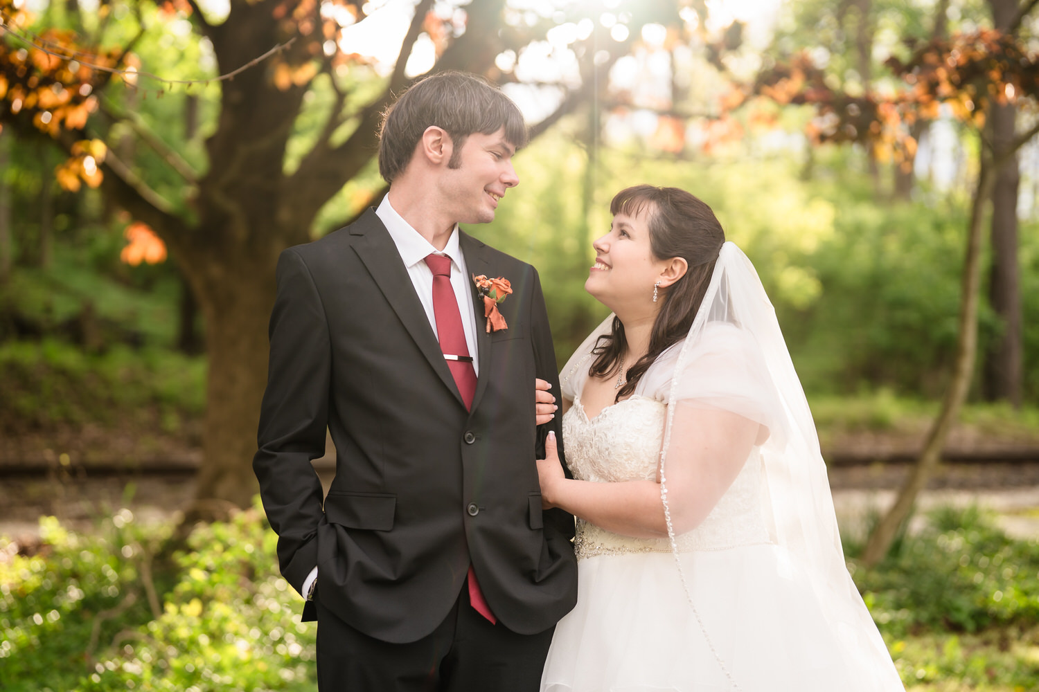 Bride and groom portrait in warm golden light beneath trees at Monocacy Bethlehem