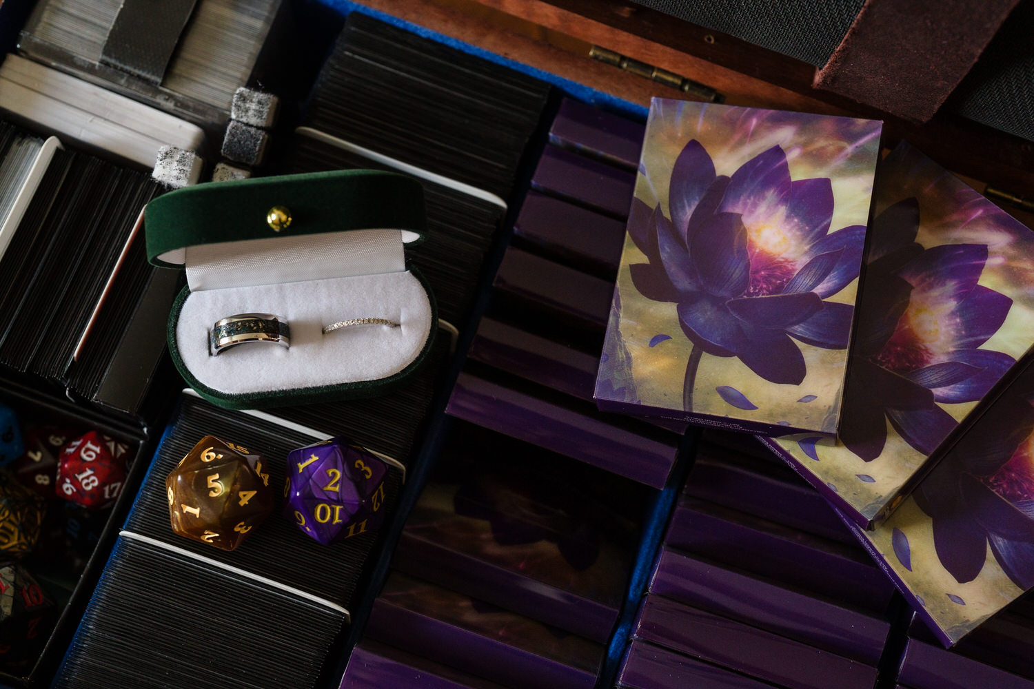 Wedding rings and groom details photographed with dark floral styling