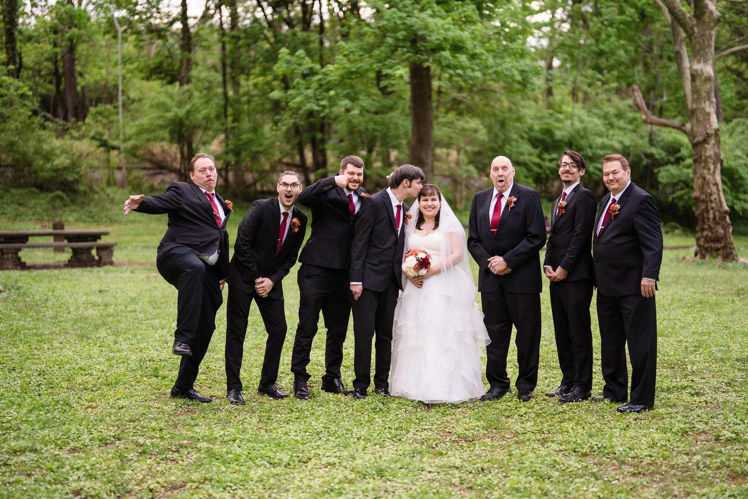 Formal wedding party portrait with bride and groom surrounded by groomsmen
