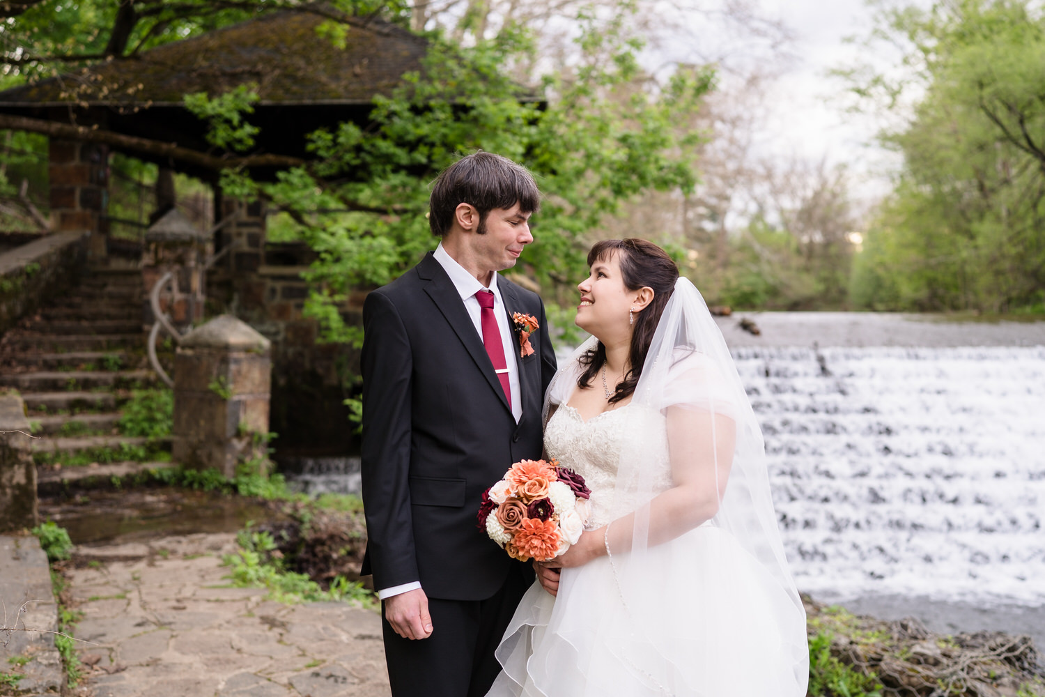 Bride and groom looking at each other with bouquet during romantic wedding portrait