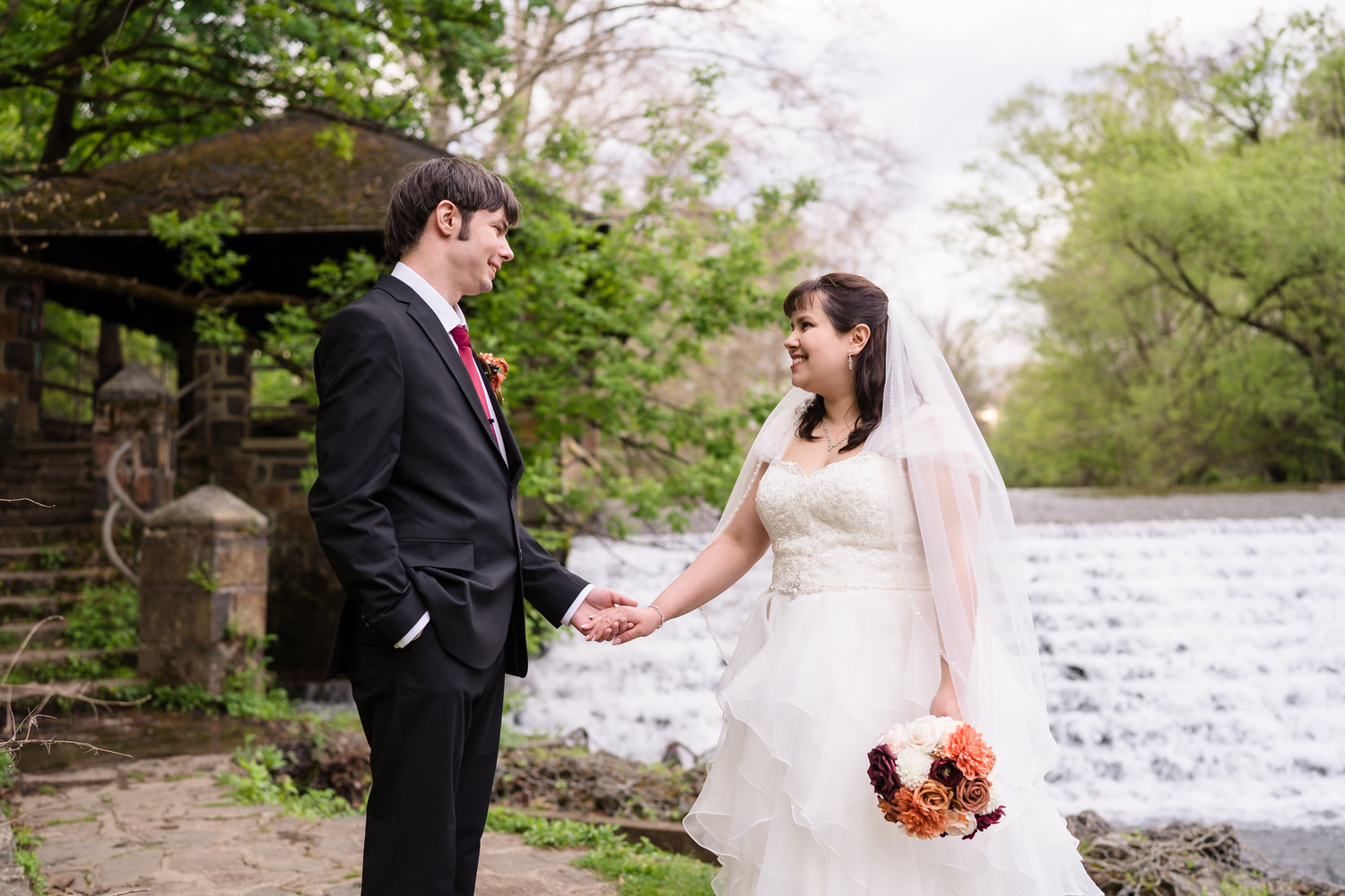 Bride and groom holding hands during outdoor wedding portraits