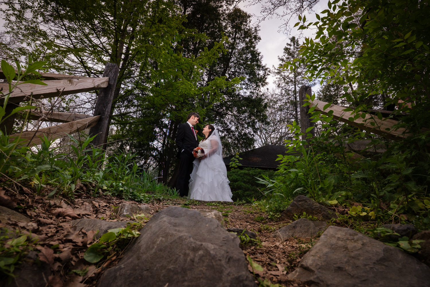 Bride and groom portrait in front of stone ruins and spring greenery