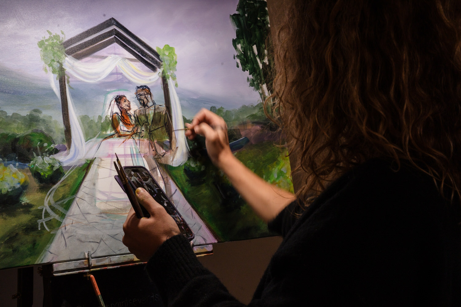 An artist paints a wedding ceremony scene on a canvas, showing a couple standing under a draped archway.